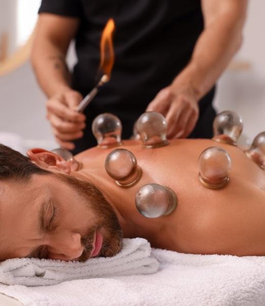 Therapist,Giving,Fire,Cupping,Treatment,To,Patient,On,Massage,Couch